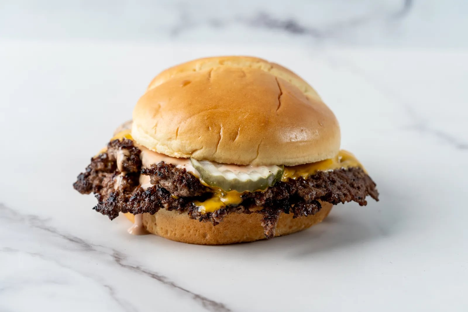 The Cheeky Smash - Premium smash burger with double smashed premium beef, secret sauce, crispy onions, pickles, toasted brioche