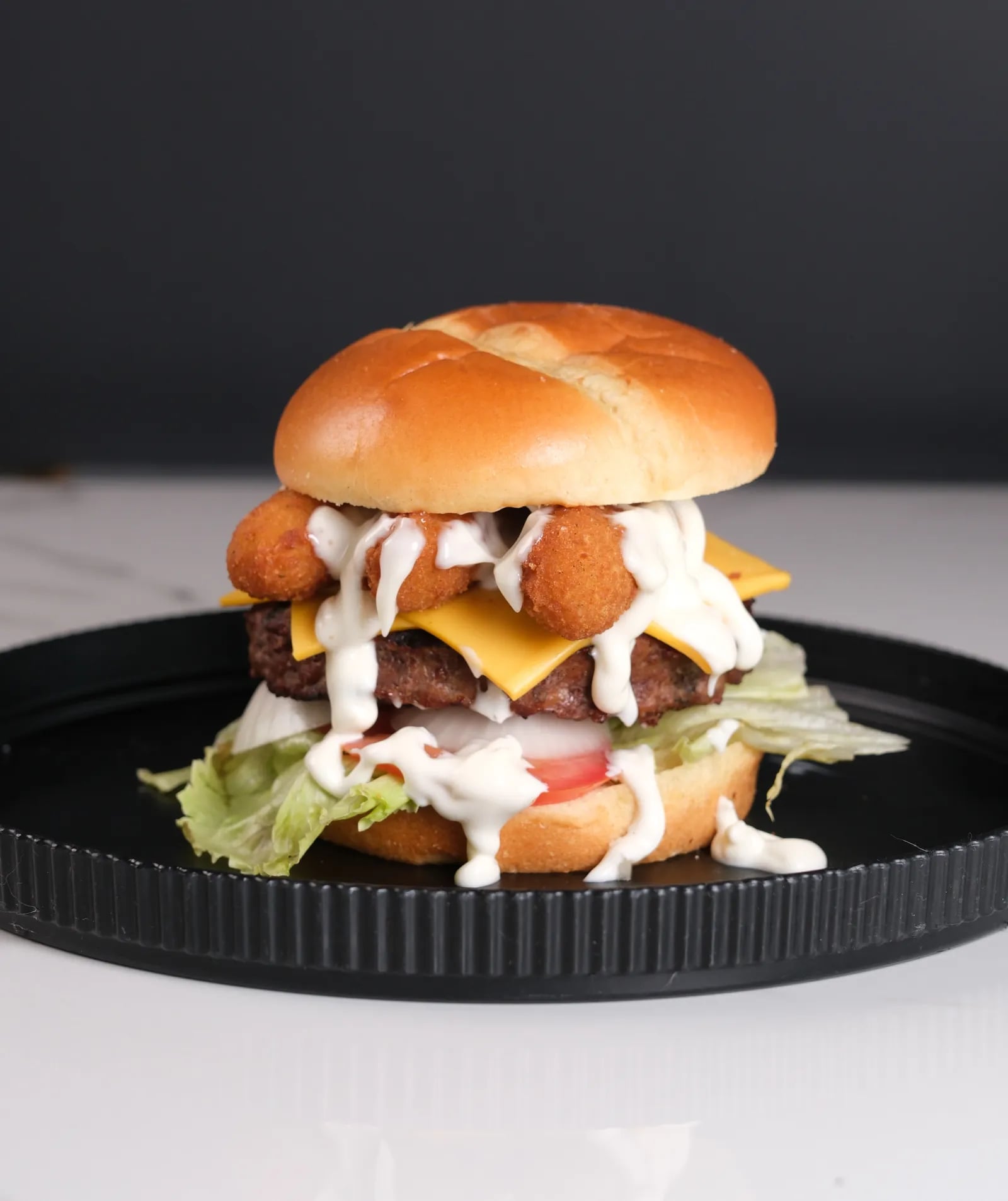 Mozza Mega - Premium smash burger with 8 oz premium beef, mozzarella sticks, ranch, lettuce, tomatoes, red onions
